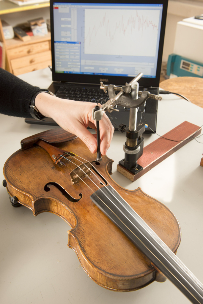 Reportage photographique: "Stradivarius, la fin de la legende". Institut Jean le Rond d'Alembert
Equipe LAM(Lutheries - Acoustique - Musique) UPMC-CNRS. Claudia Fritz (Chargée de recherche CNRS en acoustique musicale). Mesures mécaniques sur des violons. La réponse vibratoire du violon est mesurée à l'aide d'un marteau d'impact miniature, qui excite le chevalet à un coin et d'un vibromètre laser enregistrant la vitesse de vibration du chevalet à son autre coin. Cette mesure caractérise partiellement le comportement vibratoire du violon, indépendamment du violoniste. L'objectif est d'étudier la qualité des violons, telle qu'elle est perçue par les violonistes et les auditeurs, pour la mettre ensuite en relation avec leurs propriétés vibratoires et acoustiques. EN: Institut Jean le Rond d'Alembert
LAM Team. Claudia Fritz (Researcher in musical acoustic at CNRS) is measuring, using a hammer and a laser vibrometer        the vibrational behavior of the violin regardless of violinist. The goal is to study the quality of violins, as perceived by violinists and auditors, and put it in relation to their vibration and acoustic properties.