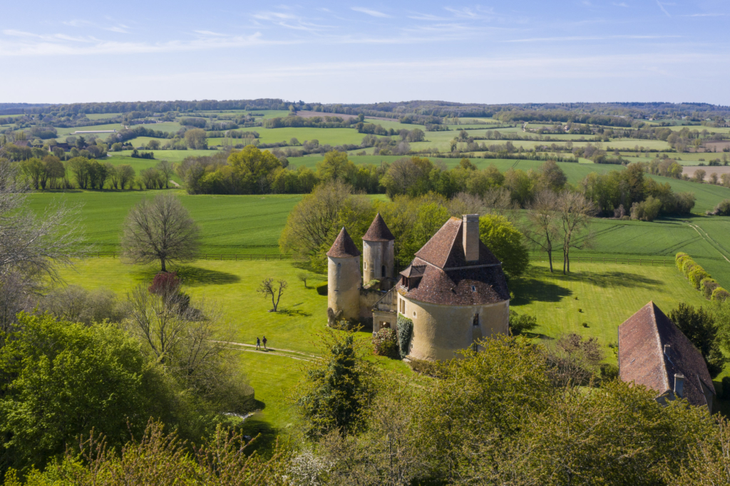 Le manoir de la Fresnaye à Saint-Germain-de-la-Coudre. La Fresnaye domine un large paysage de bocage en surplomb de la vallée de la Même. Au XVIe siècle un certain nombre de parcelles y accueillaient de la vigne.
C’est assurément le plus original de tous les manoirs percherons. C’est Mathurin de Fontenay, un fidèle soutient du futur roi Henri IV, qui est à l’origine de sa construction. Le manoir joue à nous perdre à travers les époques et les styles, de ses tours d’apparence médiévales à ses salles en ruine en passant par sa galerie Renaissance. Et que dire de cette drôle de grosse tour étrange- ment couverte qui constitue en fait le logis proprement dit. Elle a perdu au XIXe siècle un étage et sa couverture originelle, ce qui explique son apparence singulière.
C’est que la Fresnaye a connu bien des vicissitudes au cours des siècles. Il a même failli disparaître et ne doit son salut qu’à un propriétaire passionné qui, en 1989, remporta le prix « Chefs d’œuvre en péril ». Photographie extraite du projet photographique "les manoirs du Perche"