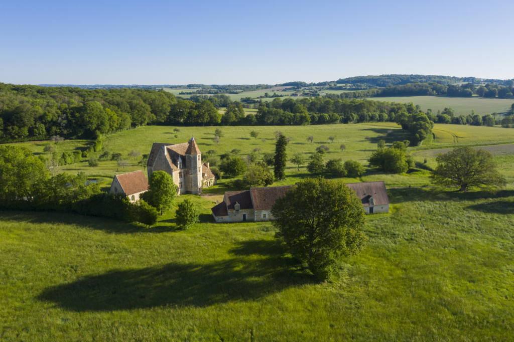 Le manoir de la Gauberdière à La Rouge. S’il fallait n’en voir qu’un, ce serait probablement celui-là. La Gauberdière ou le manoir parfait. Depuis la fin du XVe siècle, il domine le petit bourg de La Rouge, dans la vallée de la Rougette, construit sur un petit promontoire par Marguerite du Fay et son époux Louis Gaubert. Il nous apparaît entouré de bois et de cultures, intact comme au premier jour avec sa chapelle, sa boulangerie attenante au manoir et ses bâtiments d’exploitation. Dans la cour, une marre qui servait autrefois d’abreuvoir aux animaux. Derrière, un verger de pommiers. Pas de buis taillés ni de jardins apprêtés mais la grande sobriété des extérieurs d’un logis ô combien noble mais aussi à vocation agricole. La Gauberdière est abandonnée aux fermiers en 1672. Elle restera une exploitation jusqu’en 1999. Depuis cette date elle a fait l’objet d’une restauration exemplaire par ses nouveaux propriétaires. Photographie extraite du projet photographique "les manoirs du Perche"