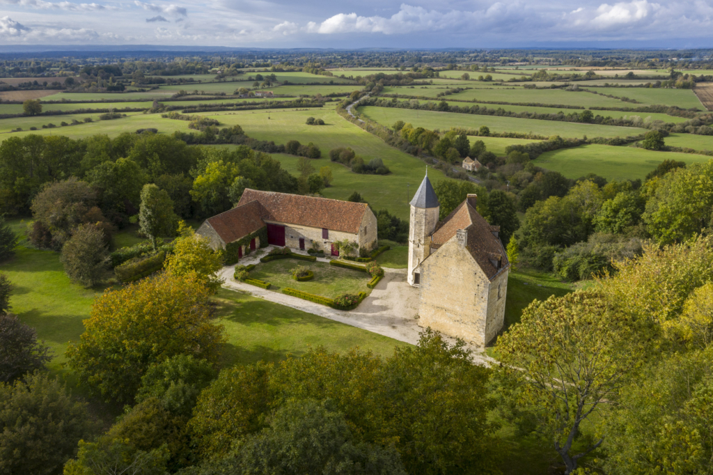 Le manoir de Vauvineux à Pervenchères. Comme nul autre dans le Perche, Vauvineux se dresse tel une sentinelle sur sa colline à deux cents mètres d’altitude. Il domine la commune de Pervenchères qui par miracle a échappé au remembrement. De toutes parts, ce ne sont que haies et pâtures. Un paysage de bocage exceptionnellement préservé. Vauvineux tire son nom du vallon qui descend vers le village. Le val vineux ou la vallée Vinosa; c’est là que l’on cultivait autrefois les vignes qui alimentaient en vin le château. Car avant d’être un manoir, Vauvineux fut une place forte avec donjon dont l’existence est avérée dès le XIe siècle. Ce n’est qu’après la guerre de Cent Ans, à la fin du XVe siècle, que le manoir fut érigé sur les ruines du château fort.
C’est alors un bâtiment beaucoup plus imposant qu’aujourd’hui. Il compte un étage de plus et de très hauts combles. À l’arrière se déploie une grosse tour. Ces éléments, en mauvais état, ont été détruits en 1900 par le fermier qui occupait les lieux. Photographie extraite du projet photographique "les manoirs du Perche"